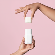 Kiima refillable deodorant applicator in use on a full pink background